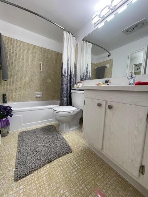 full bathroom featuring vanity, toilet, and shower / tub combo with curtain