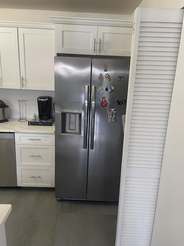 kitchen featuring white cabinetry, backsplash, and stainless steel appliances