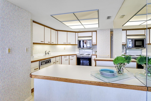 kitchen featuring built in microwave, black microwave, sink, white cabinets, and electric range