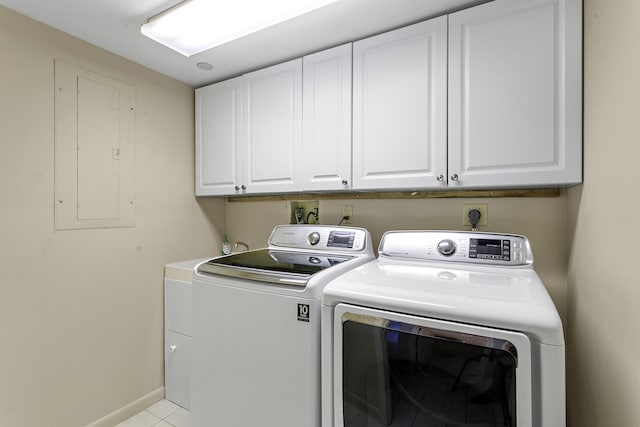 washroom with light tile patterned flooring, cabinets, electric panel, and washing machine and dryer