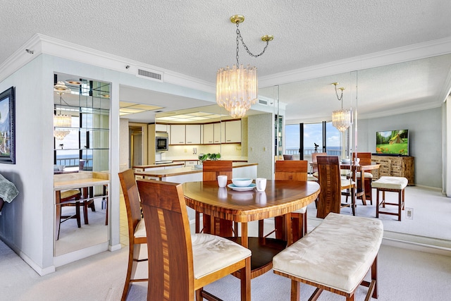 dining area featuring crown molding, light carpet, a textured ceiling, and a chandelier