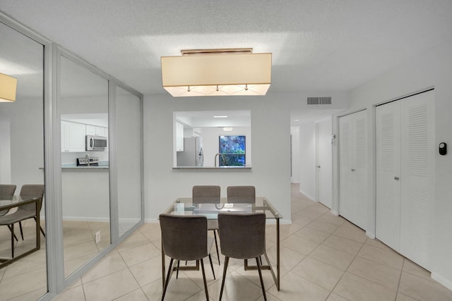 tiled dining space featuring a textured ceiling