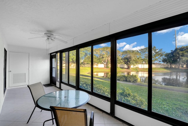 unfurnished sunroom with ceiling fan and a water view