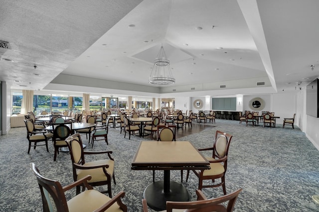 carpeted dining area with vaulted ceiling