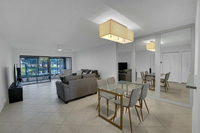 tiled dining room with ceiling fan and a textured ceiling