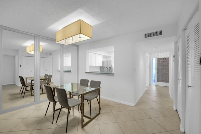 dining space featuring light tile patterned floors and a textured ceiling