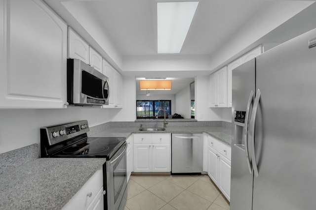 kitchen with white cabinetry, appliances with stainless steel finishes, sink, and light tile patterned flooring