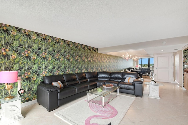 living room with light tile patterned floors, a textured ceiling, an inviting chandelier, and wallpapered walls