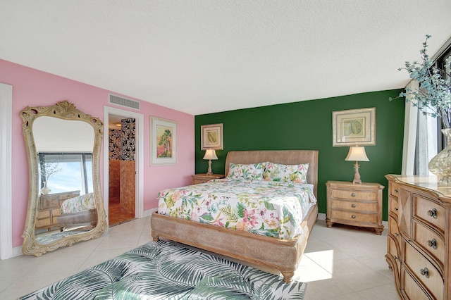 bedroom with baseboards, visible vents, a textured ceiling, and light tile patterned flooring