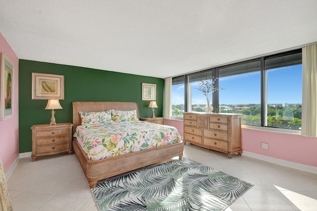 bedroom featuring light tile patterned floors, baseboards, and a textured ceiling