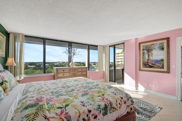 tiled bedroom featuring a textured ceiling, multiple windows, and baseboards