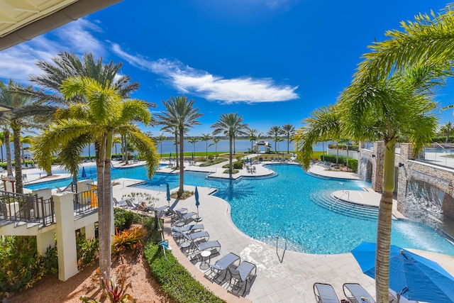 view of pool featuring pool water feature and a water view