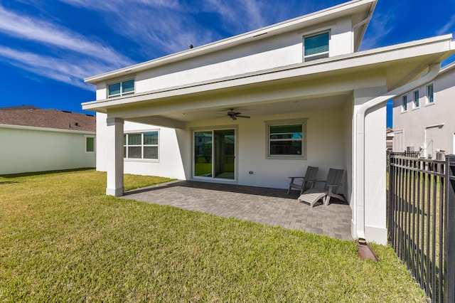 back of house featuring ceiling fan, a patio area, and a lawn