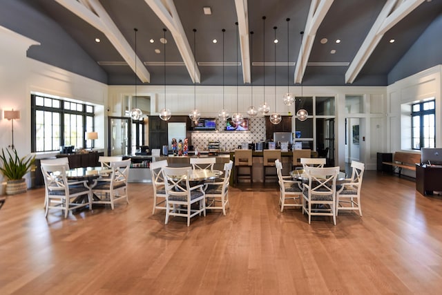 dining room featuring plenty of natural light, high vaulted ceiling, and beamed ceiling