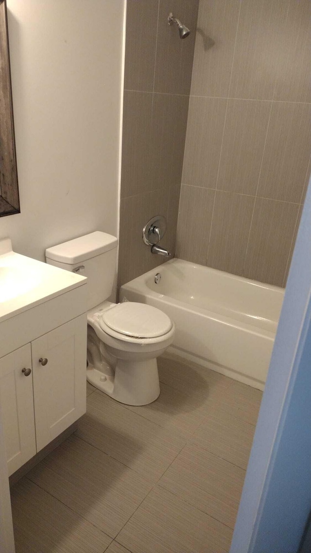 full bathroom with tiled shower / bath, vanity, toilet, and tile patterned floors