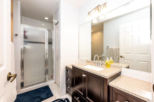 bathroom featuring vanity, an enclosed shower, and tile patterned floors