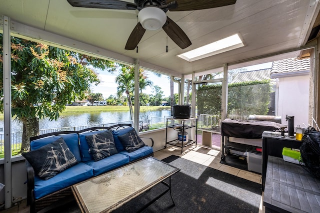 sunroom featuring a water view, ceiling fan, a healthy amount of sunlight, and a skylight