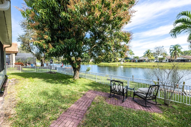 view of yard with a water view and a lanai