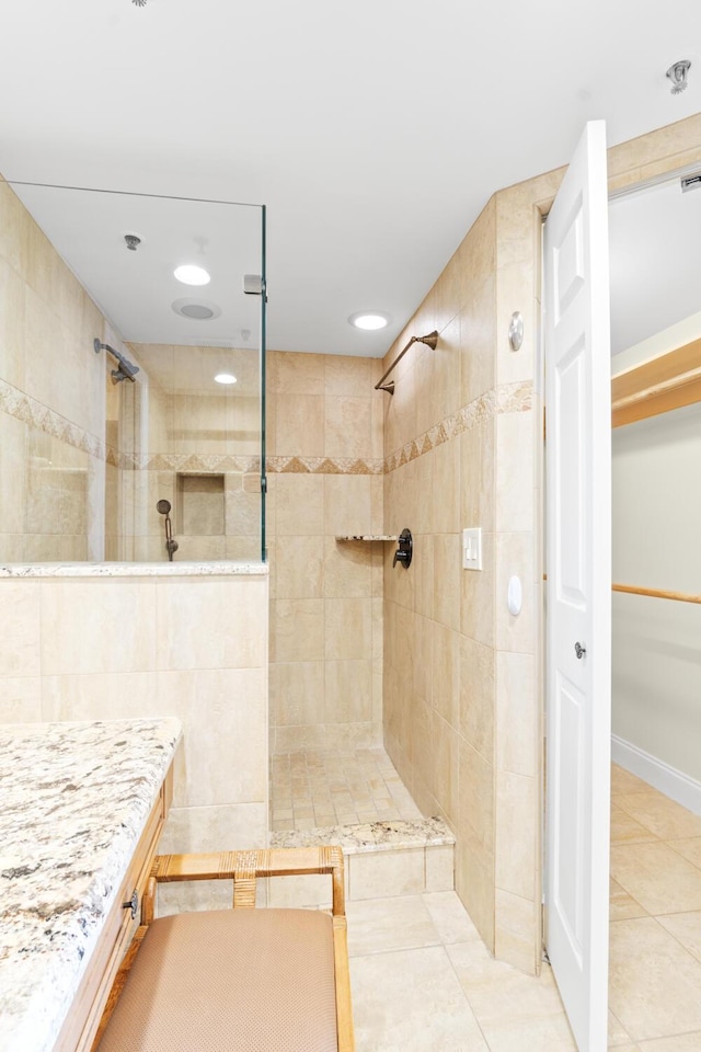 bathroom with tile patterned flooring and tiled shower