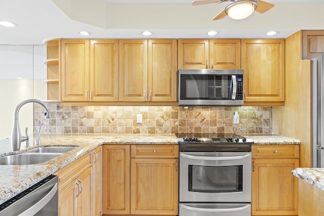 kitchen featuring stainless steel appliances, tasteful backsplash, sink, and light stone counters