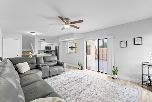 living room featuring ceiling fan and light hardwood / wood-style flooring