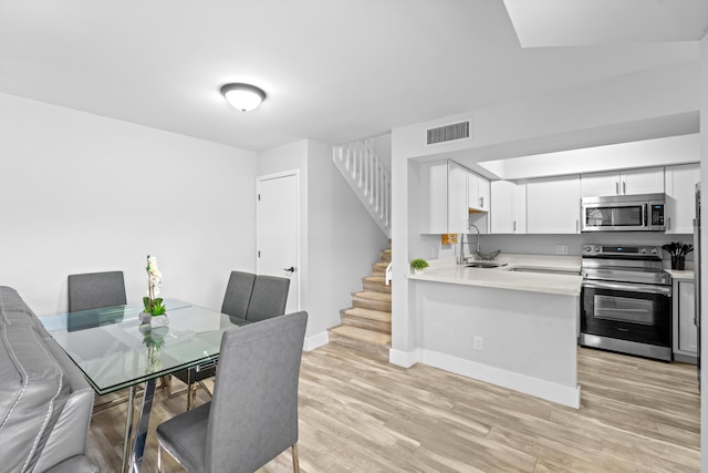 dining room with sink and light wood-type flooring