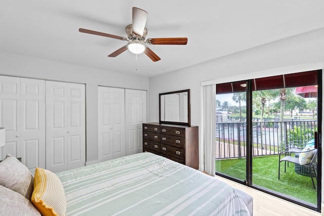 bedroom featuring hardwood / wood-style flooring, ceiling fan, access to outside, and two closets