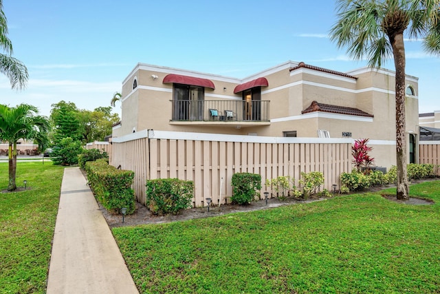 view of property exterior featuring a lawn and a balcony