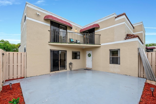 rear view of house featuring a balcony and a patio area