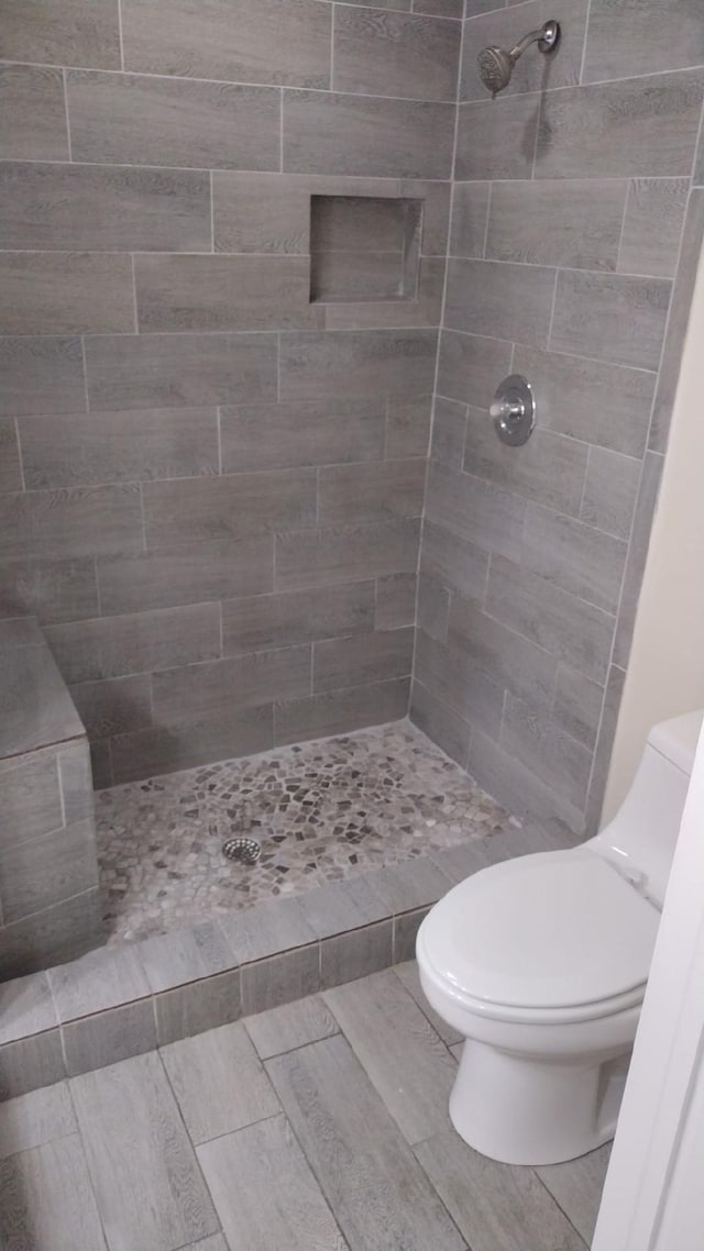 bathroom featuring toilet and tiled shower