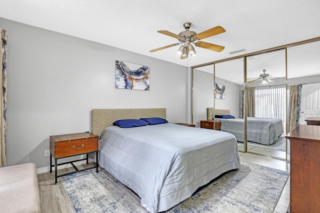 bedroom featuring ceiling fan, light hardwood / wood-style floors, and a closet