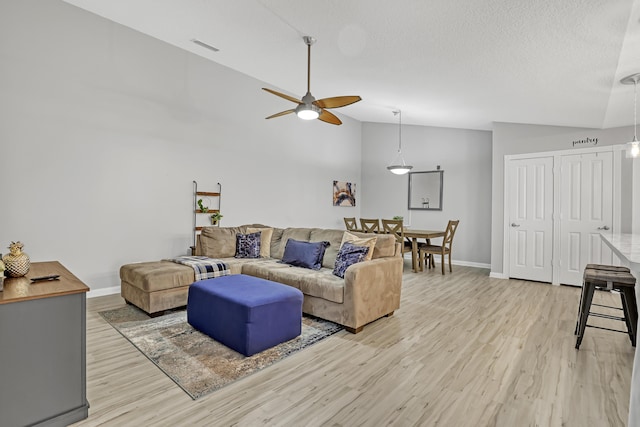 2302 Appleton Ct, Palm Beach Gardens, FL 33403 - living room featuring light wood-style flooring, a ceiling fan, baseboards, a textured ceiling, and high vaulted ceiling