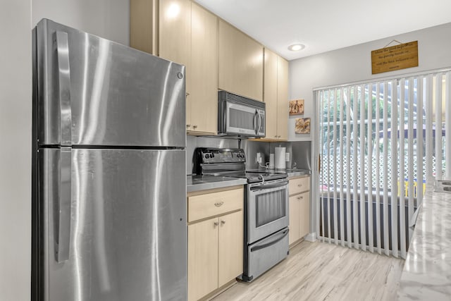 kitchen with appliances with stainless steel finishes, light brown cabinetry, and light hardwood / wood-style floors