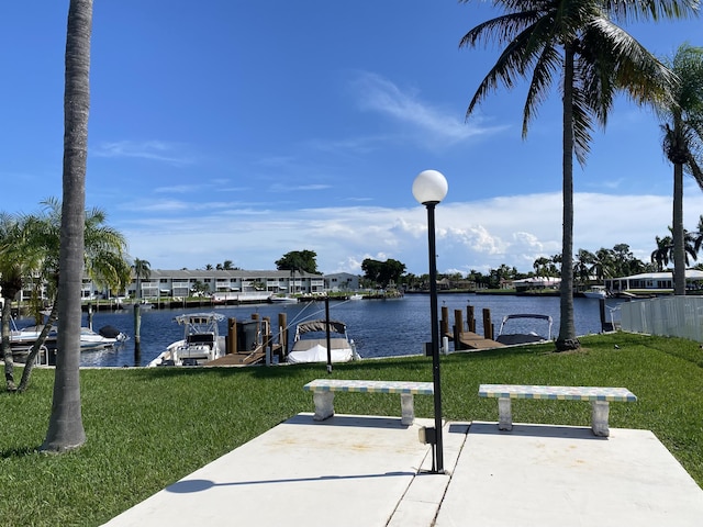 dock area featuring a water view and a lawn