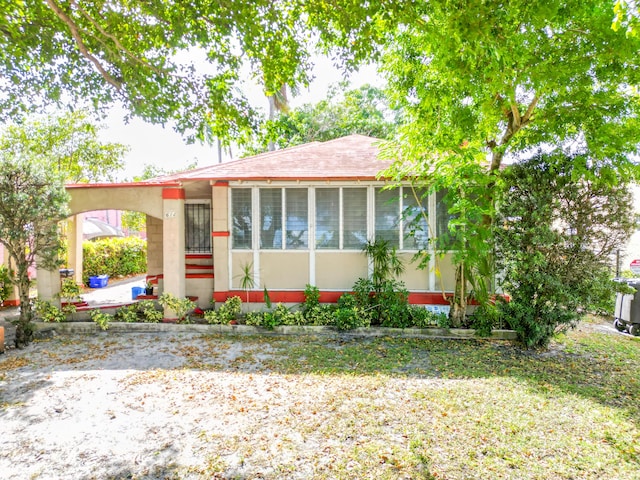 view of front of home with a carport and a sunroom