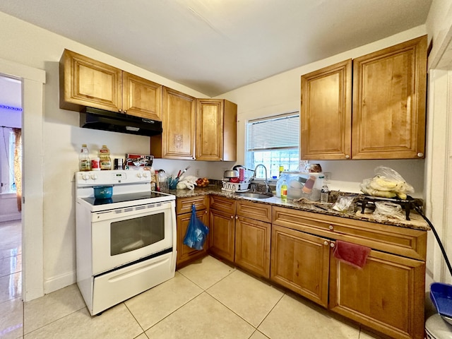 kitchen with light tile patterned flooring, dark stone counters, sink, and electric range