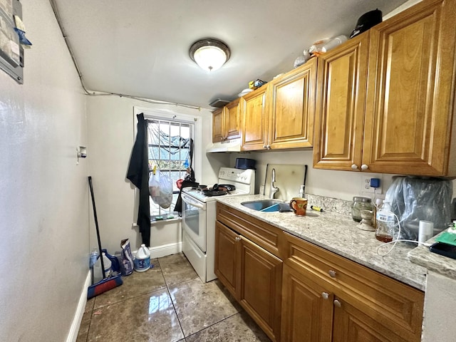 kitchen featuring white range, sink, light tile patterned floors, and light stone countertops