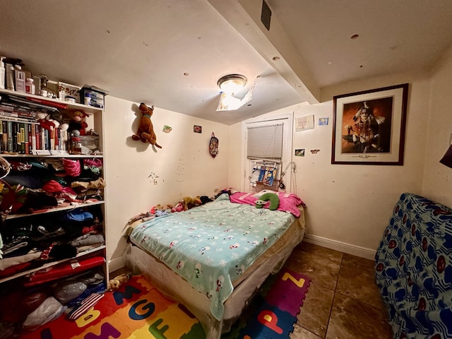 bedroom with lofted ceiling with beams and dark tile patterned floors