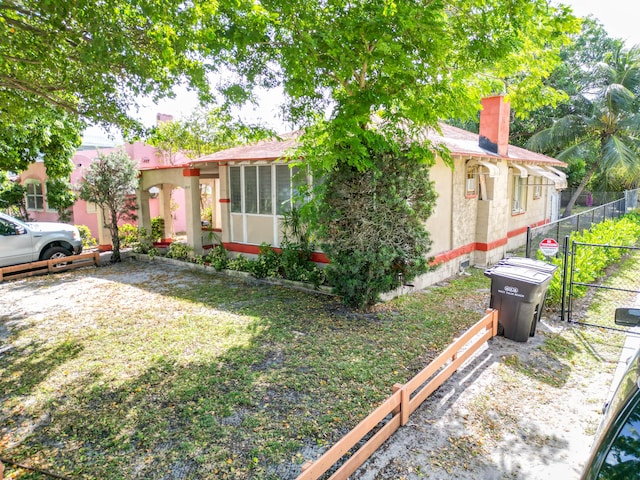 view of front facade with a front yard and a sunroom