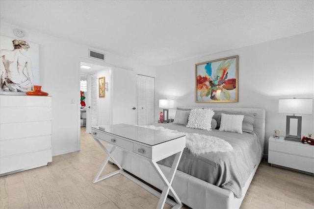 bedroom featuring a closet, visible vents, and wood finished floors