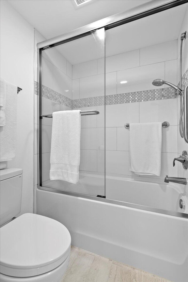 full bathroom with shower / bath combination with glass door and toilet