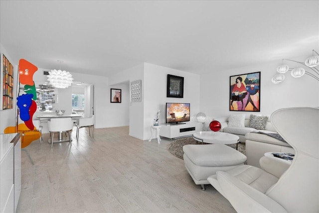 living area with a notable chandelier and light wood-style floors