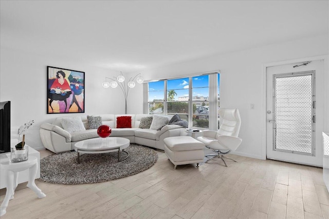 living area featuring light wood finished floors and baseboards