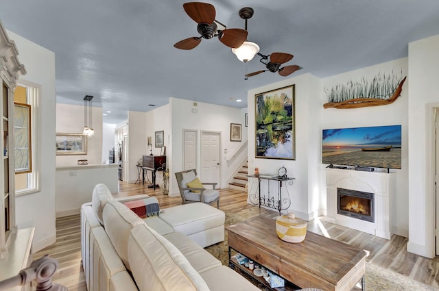 living room featuring light hardwood / wood-style flooring and ceiling fan