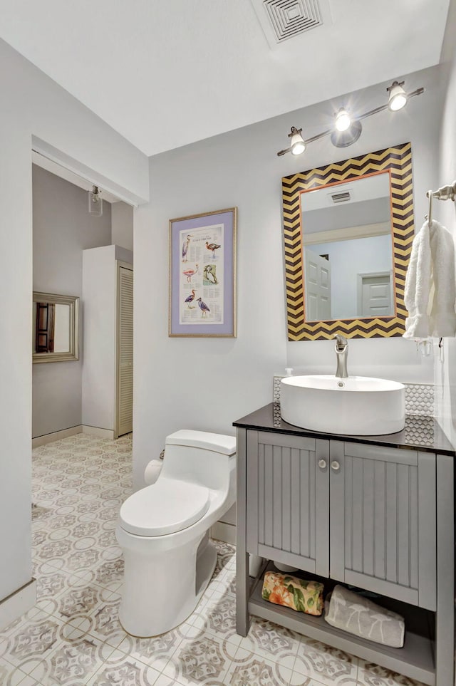 bathroom with vanity, tile patterned flooring, and toilet