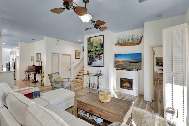 living room with light hardwood / wood-style flooring and ceiling fan