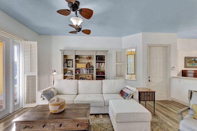 living room with ceiling fan and light wood-type flooring