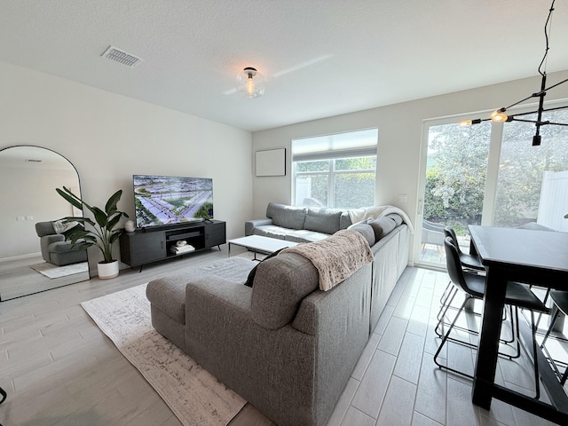 living room with a textured ceiling and light wood-type flooring