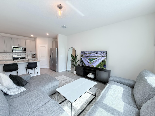 living room with sink and light hardwood / wood-style floors