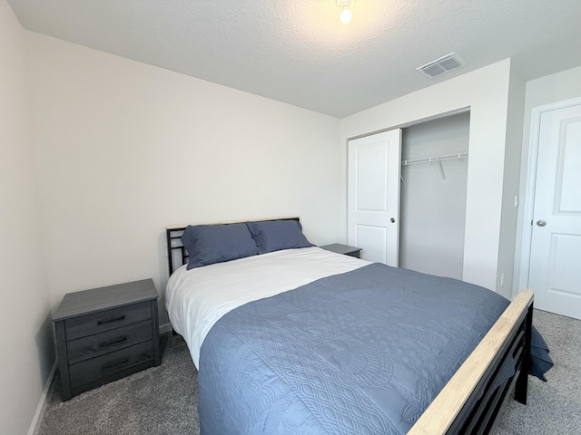 bedroom with dark carpet, a closet, and a textured ceiling